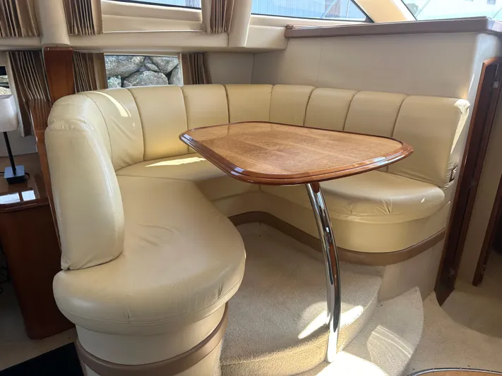  Yacht Photos Pics Interior of 2004 Carver 420 Mariner with beige leather seating and wooden table.
