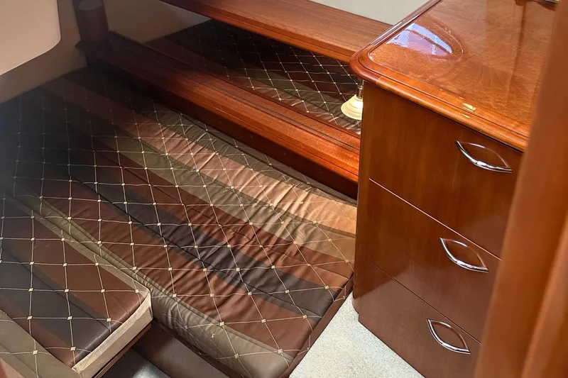  Yacht Photos Pics 2004 Carver 420 Mariner cabin with wooden furniture and quilted bedding.