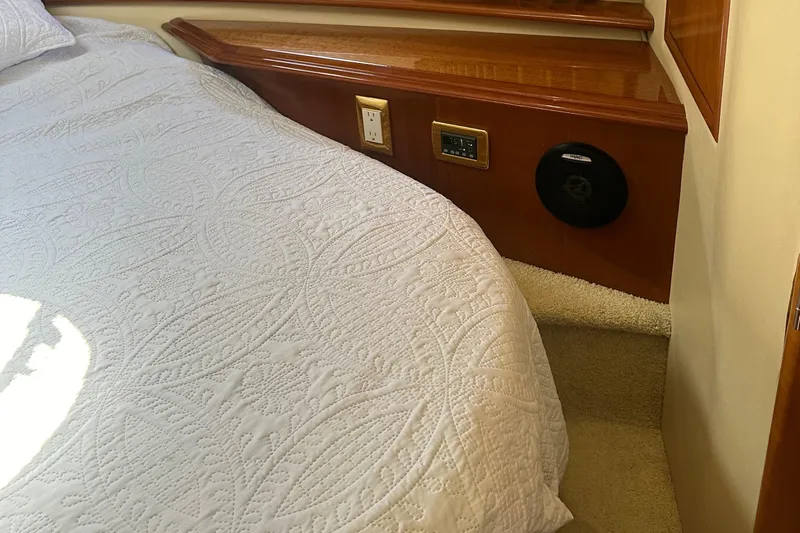  Yacht Photos Pics Interior of 2004 Carver 420 Mariner with quilted bedding and wooden paneling.