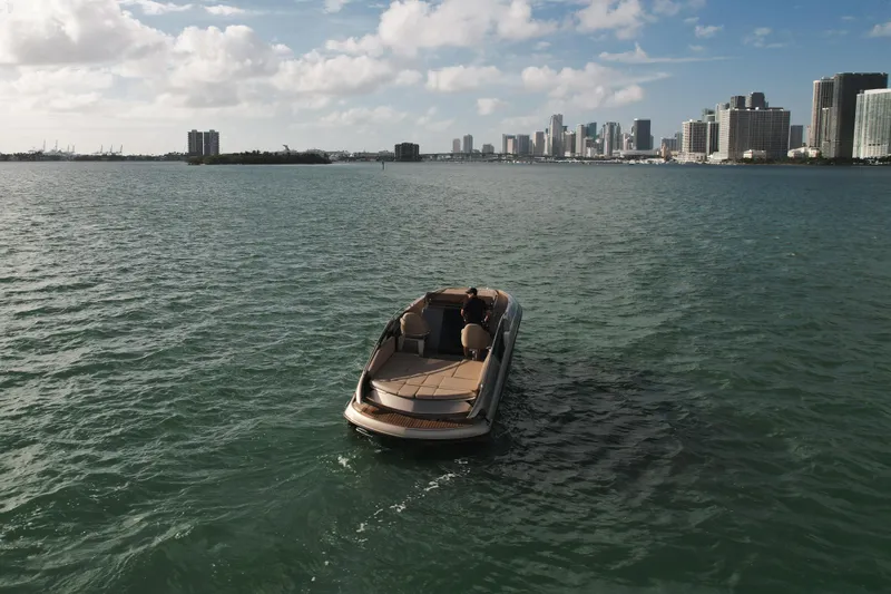  Yacht Photos Pics A 2016 Wider 32 boat on water with city skyline in the background.