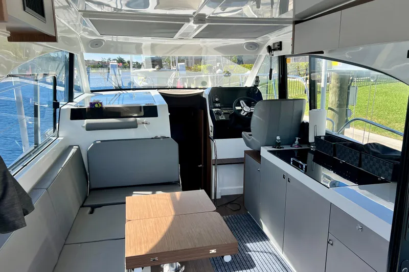  Yacht Photos Pics Interior of 2024 Beneteau Antares 11, featuring modern helm, seating, and kitchenette.