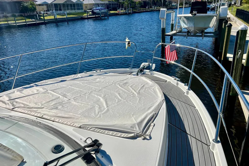  Yacht Photos Pics 2024 Beneteau Antares 11 boat docked, featuring a covered deck and American flag.