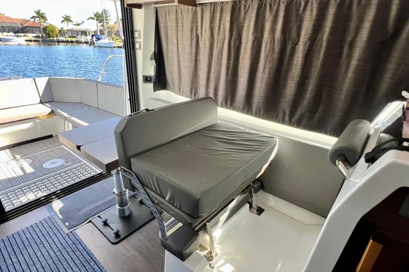  Yacht Photos Pics 2024 Beneteau Antares 11 interior with seating, table, and waterfront view.