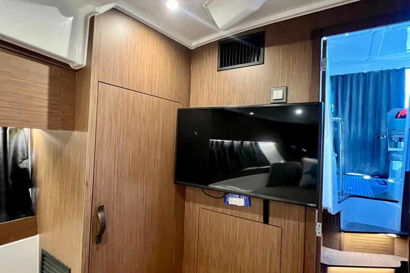  Yacht Photos Pics Interior of 2024 Beneteau Antares 11 with wood paneling and mounted TV.