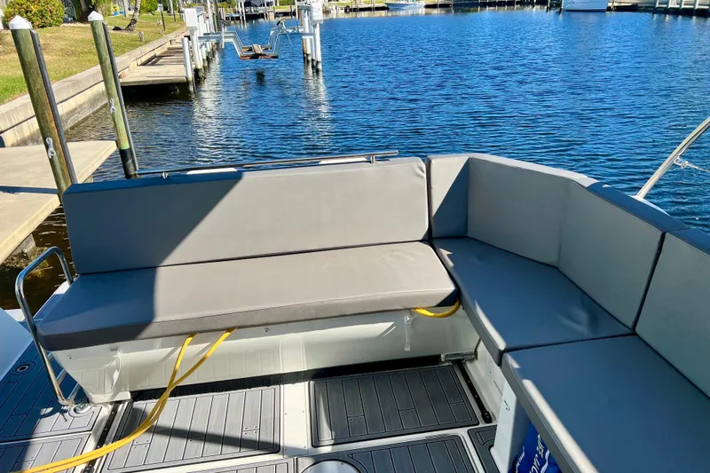  Yacht Photos Pics 2024 Beneteau Antares 11 boat interior with gray seating, docked by the water.