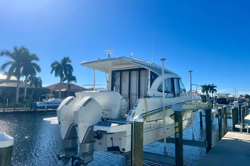  Yacht Photos Pics 2024 Beneteau Antares 11 docked, featuring dual outboard engines, under clear blue sky.