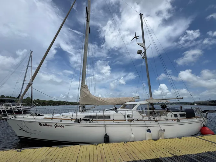 Northern Goose Yacht Photos Pics Sailboat "Northern Goose" docked, Amel Mango 52, 1980 model, under a partly cloudy sky.