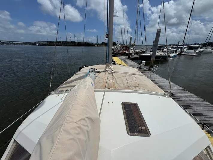Northern Goose Yacht Photos Pics Sailboat Amel Mango 52, 1980 model, docked at marina under cloudy sky.