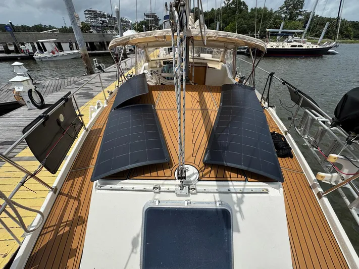 Northern Goose Yacht Photos Pics 1980 Amel Mango 52 sailboat with solar panels on deck, docked at marina.