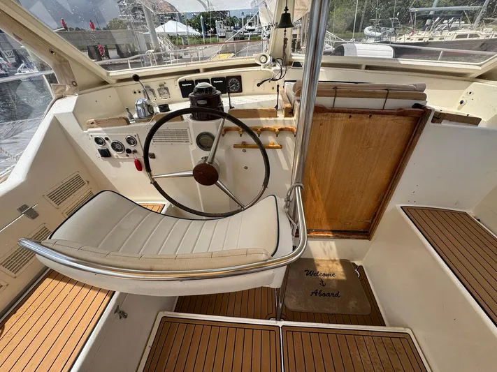 Northern Goose Yacht Photos Pics Cockpit of 1980 Amel Mango 52 sailboat with steering wheel and welcome mat.