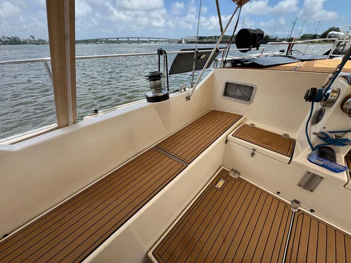 Northern Goose Yacht Photos Pics Cockpit of 1980 Amel Mango 52 sailboat with teak flooring, overlooking water and bridge.