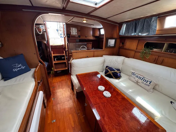 Northern Goose Yacht Photos Pics Interior of 1980 Amel Mango 52 yacht with wooden finishes and white seating.