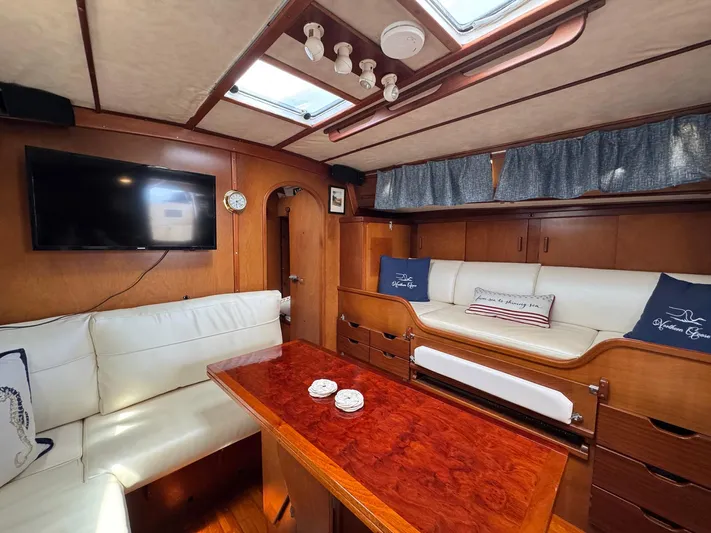 Northern Goose Yacht Photos Pics Interior of 1980 Amel Mango 52 yacht with cozy seating and wooden table.