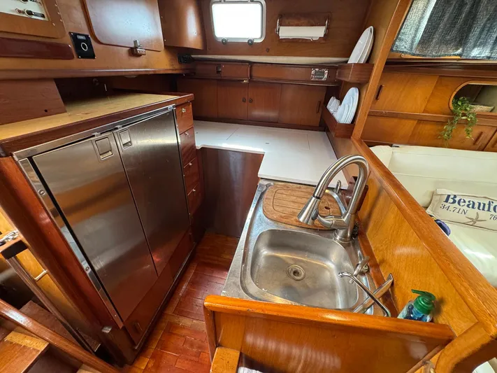 Northern Goose Yacht Photos Pics Galley of 1980 Amel Mango 52 sailboat with wood cabinetry and stainless steel sink.