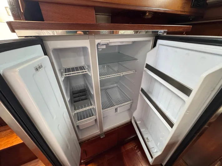 Northern Goose Yacht Photos Pics Open refrigerator inside 1980 Amel Mango 52 yacht, featuring shelves and door storage.