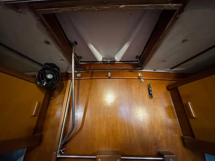 Northern Goose Yacht Photos Pics Interior of 1980 Amel Mango 52 yacht, featuring wooden paneling and a small fan.