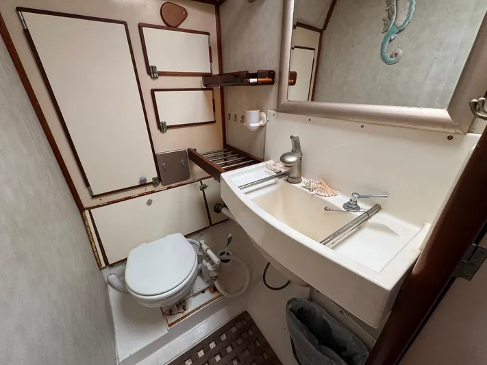 Northern Goose Yacht Photos Pics Compact bathroom in 1980 Amel Mango 52 yacht with sink, toilet, and mirror.