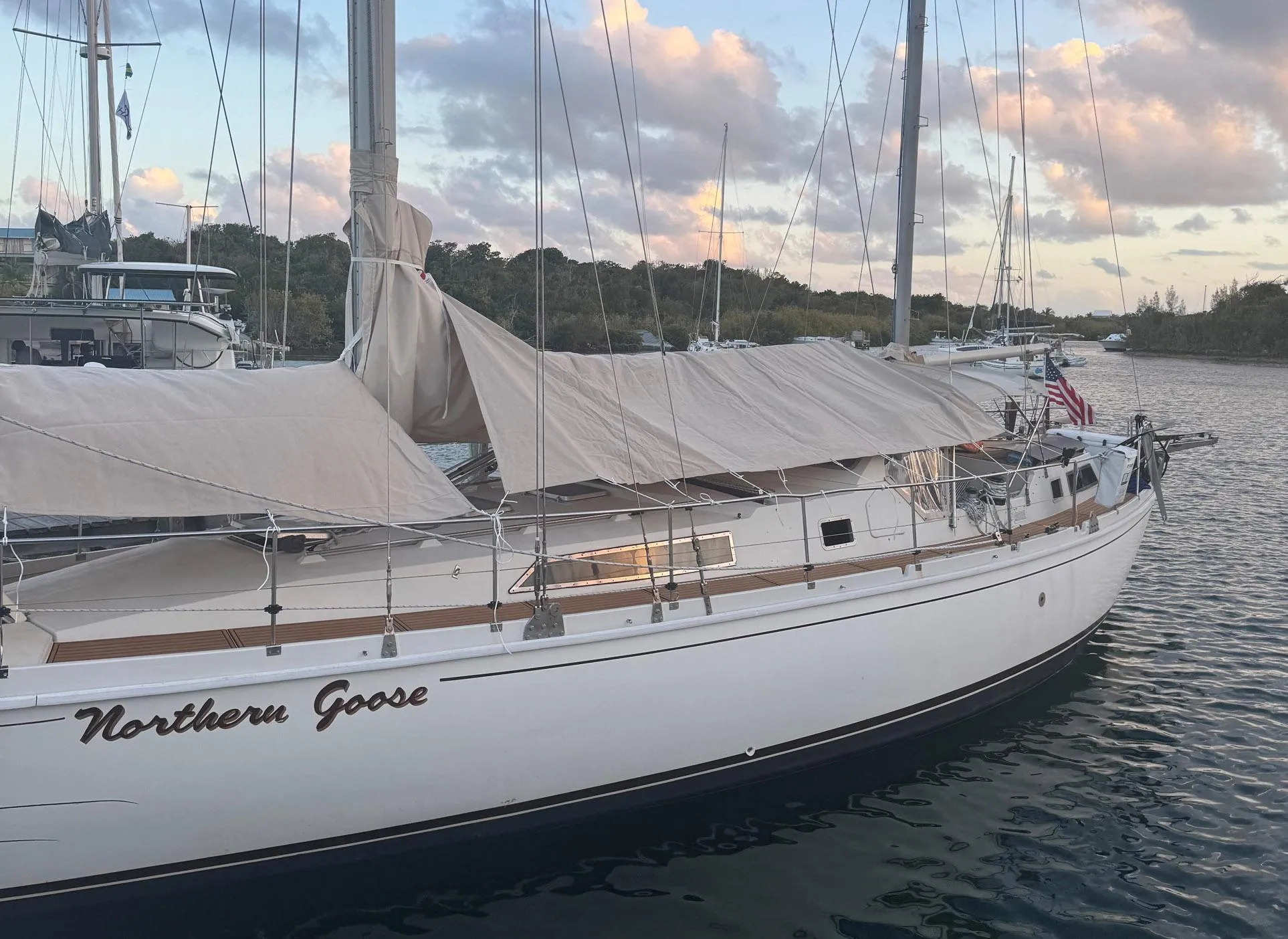 1980 Amel Mango 52 sailboat named "Northern Goose" docked in a serene harbor.