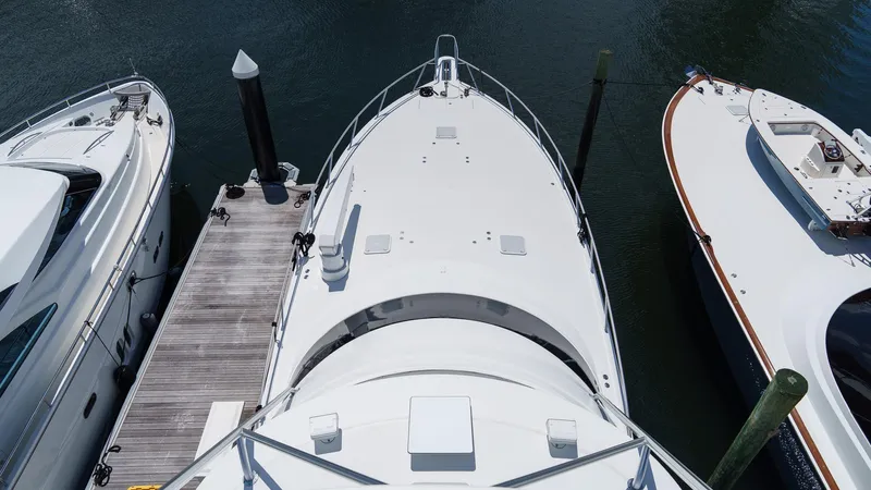Benedetta Yacht Photos Pics Aerial view of a 2012 Viking 70 Enclosed Bridge yacht docked between boats.