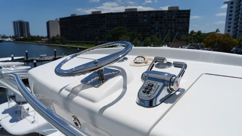 Benedetta Yacht Photos Pics Steering controls of a 2012 Viking 70 Enclosed Bridge yacht, docked in a marina.