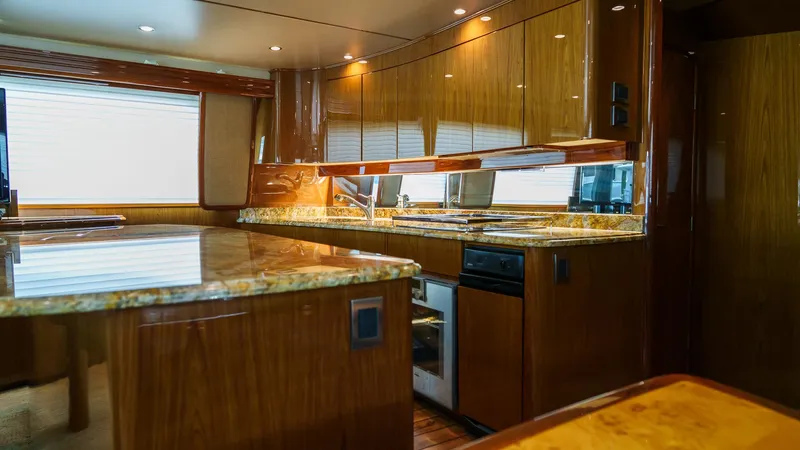 Benedetta Yacht Photos Pics Luxurious kitchen interior of 2012 Viking 70 Enclosed Bridge yacht with wood and granite finishes.