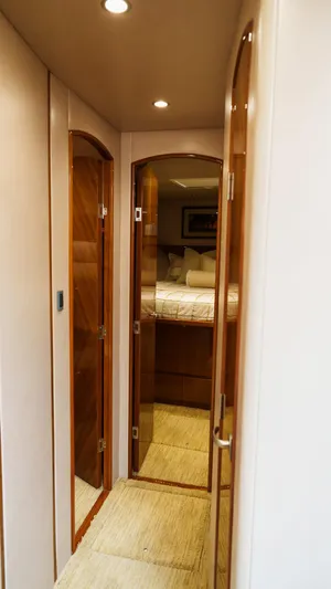 Benedetta Yacht Photos Pics Interior hallway of 2012 Viking 70 Enclosed Bridge yacht, featuring wooden doors and cozy lighting.