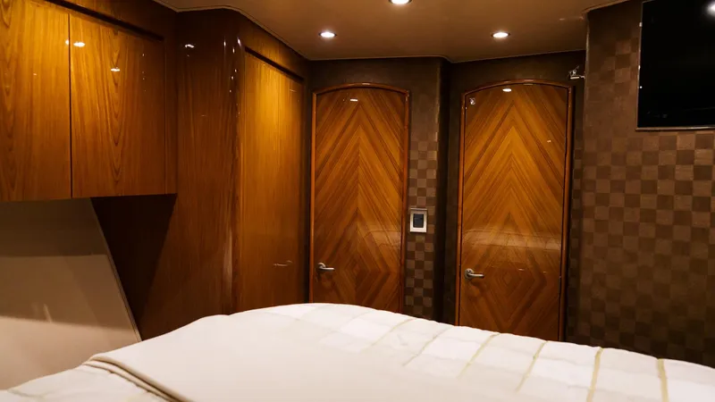 Benedetta Yacht Photos Pics Luxurious interior of 2012 Viking 70 Enclosed Bridge yacht bedroom with wood finishes.