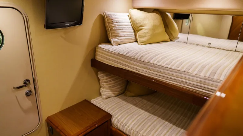 Benedetta Yacht Photos Pics Interior of 2012 Viking 70 Enclosed Bridge yacht with cozy bunk beds and TV.