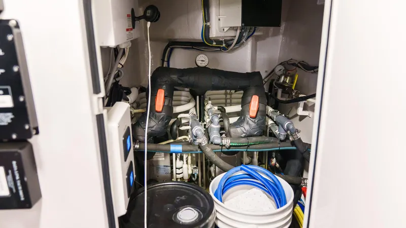 Benedetta Yacht Photos Pics Engine room of 2012 Viking 70 Enclosed Bridge yacht, featuring pipes and equipment.