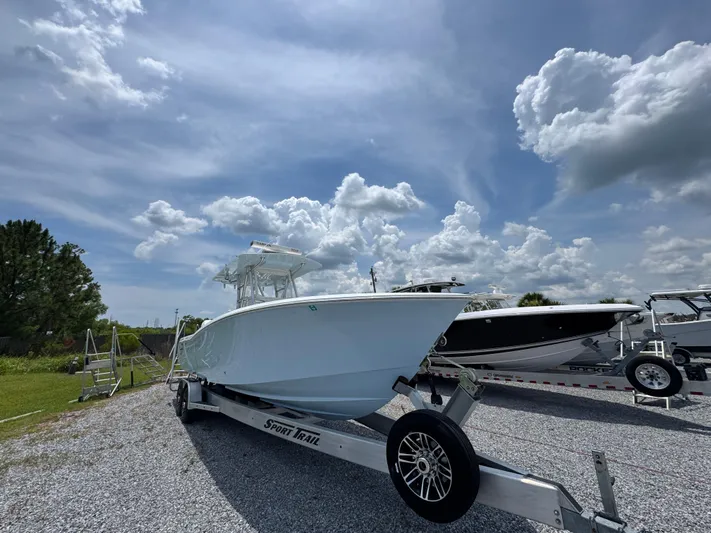  Yacht Photos Pics 2017 Invincible 33 Open Fisherman boat on trailer under cloudy sky.