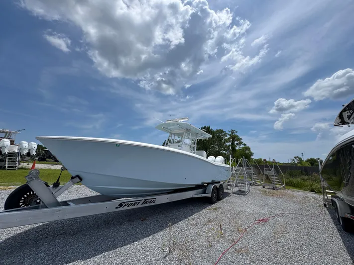  Yacht Photos Pics 2017 Invincible 33 Open Fisherman boat on trailer under a partly cloudy sky.