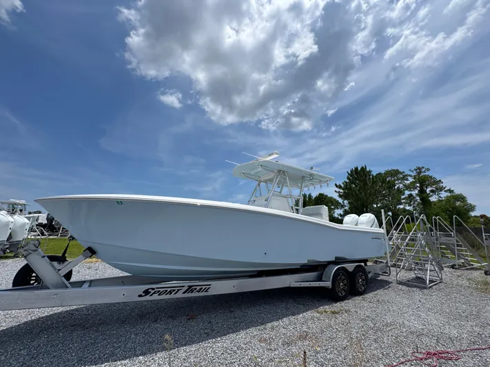  Yacht Photos Pics 2017 Invincible 33 Open Fisherman boat on trailer under blue sky.
