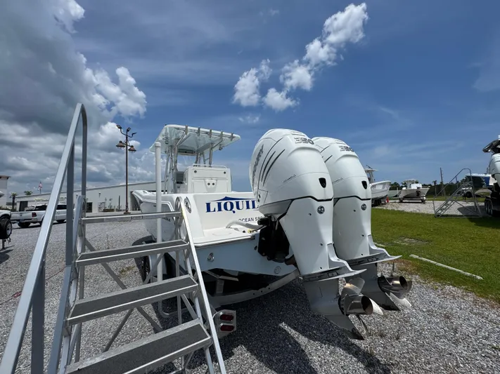  Yacht Photos Pics 2017 Invincible 33 Open Fisherman boat with twin outboard engines, parked on gravel.