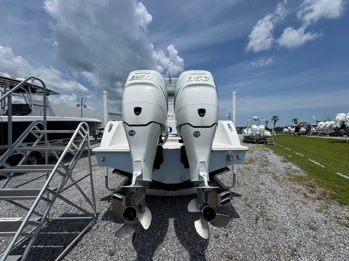  Yacht Photos Pics 2017 Invincible 33 Open Fisherman with twin outboard engines, parked on gravel under a cloudy sky.