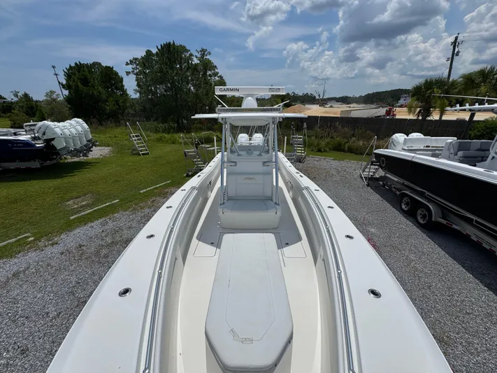  Yacht Photos Pics 2017 Invincible 33 Open Fisherman boat on display, surrounded by greenery and other boats.