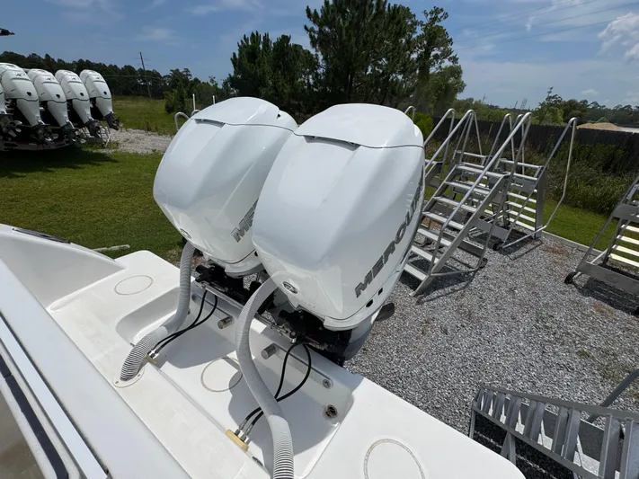  Yacht Photos Pics 2017 Invincible 33 Open Fisherman with twin Mercury outboard engines, parked on gravel.