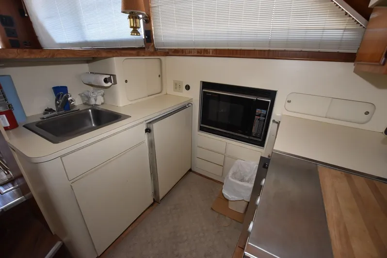 Russell Hatt Yacht Photos Pics Compact kitchen area in a 1988 Hatteras 48 Convertible yacht with sink and microwave.