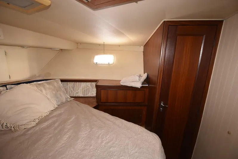 Russell Hatt Yacht Photos Pics Interior cabin of 1988 Hatteras 48 Convertible yacht with bed and wooden cabinetry.