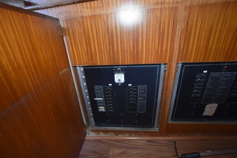 Russell Hatt Yacht Photos Pics Electrical panel inside 1988 Hatteras 48 Convertible yacht, featuring wood paneling.