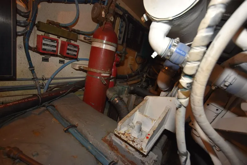 Russell Hatt Yacht Photos Pics Engine room of 1988 Hatteras 48 Convertible with visible fire extinguisher and piping.