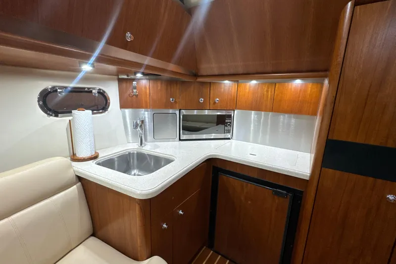 Blue Sky Yacht Photos Pics 2006 Tiara Yachts 3600 Sovran interior kitchen with sink, microwave, and wooden cabinetry.