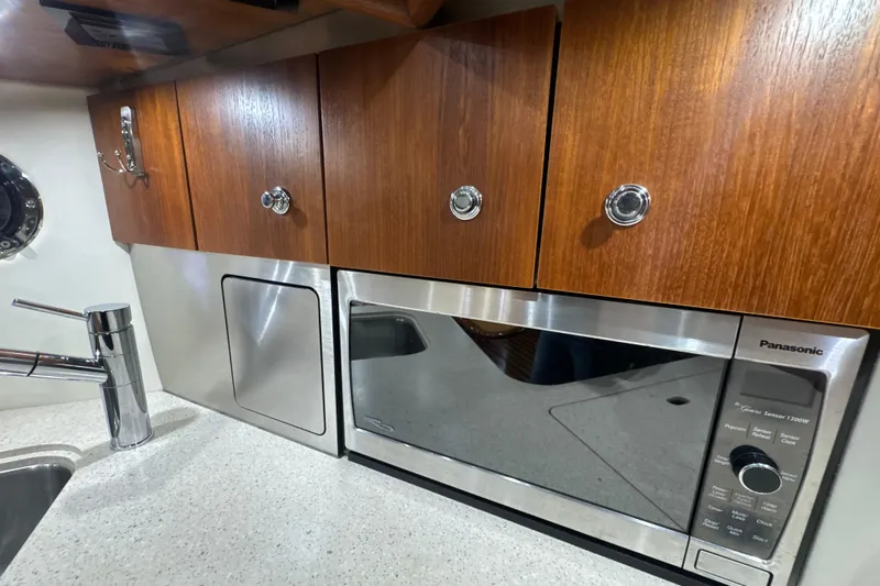 Blue Sky Yacht Photos Pics 2006 Tiara Yachts 3600 Sovran galley with wooden cabinets and stainless steel appliances.