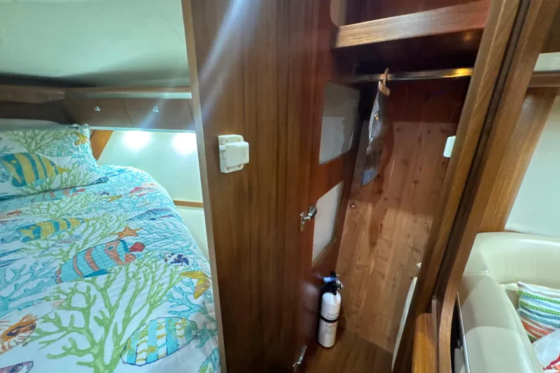 Blue Sky Yacht Photos Pics 2006 Tiara Yachts 3600 Sovran cabin with colorful bedding and wooden interior.