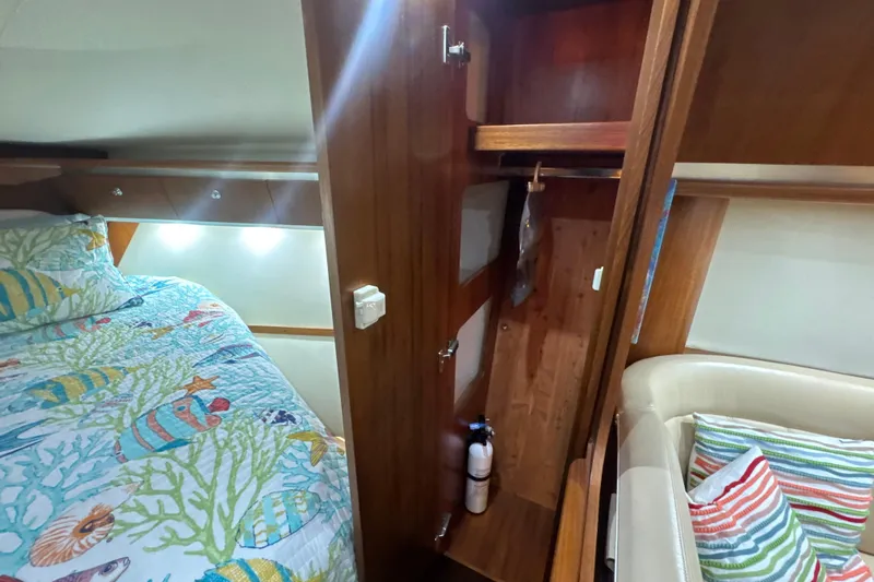 Blue Sky Yacht Photos Pics Interior of 2006 Tiara Yachts 3600 Sovran with colorful bedding and wooden cabinetry.