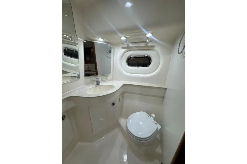 Blue Sky Yacht Photos Pics 2006 Tiara Yachts 3600 Sovran bathroom with sink, toilet, and porthole window.