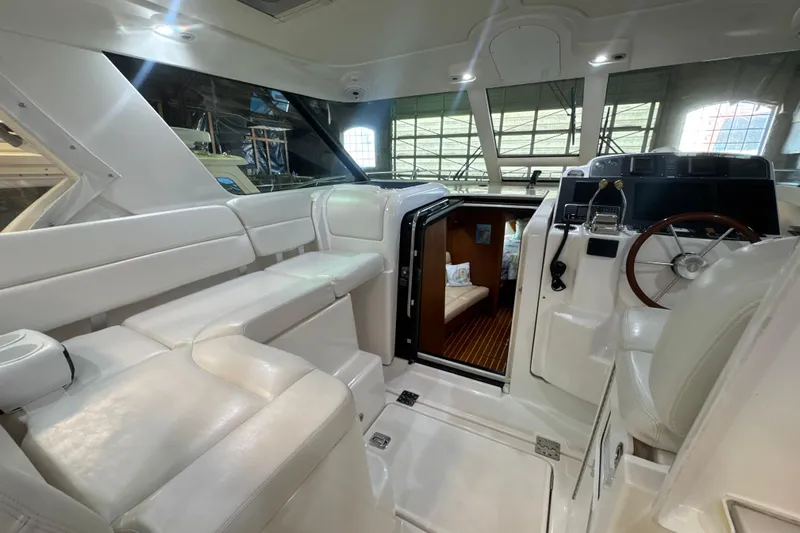 Blue Sky Yacht Photos Pics 2006 Tiara Yachts 3600 Sovran interior with white seating and wooden steering wheel.