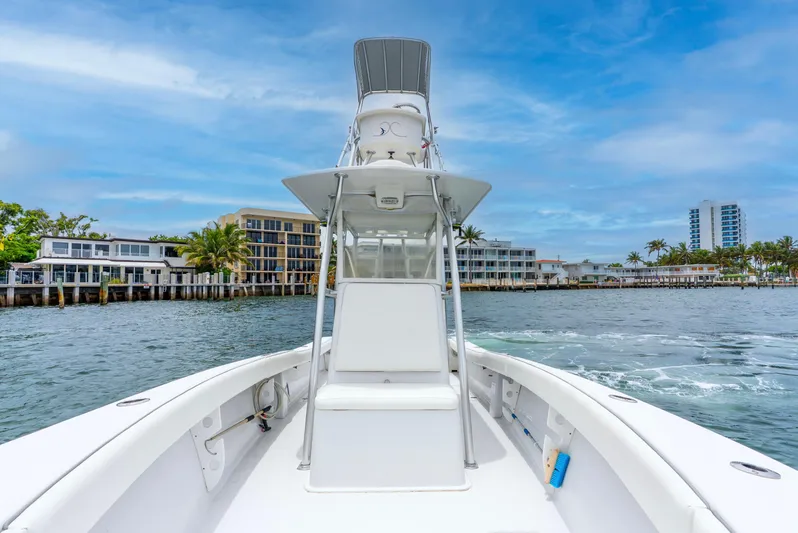  Yacht Photos Pics 2018 Ocean Runner 29 boat cruising near waterfront buildings under a clear blue sky.