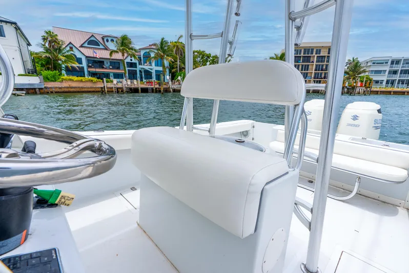  Yacht Photos Pics 2018 Ocean Runner 29 boat interior with white seating, steering wheel, and waterfront view.