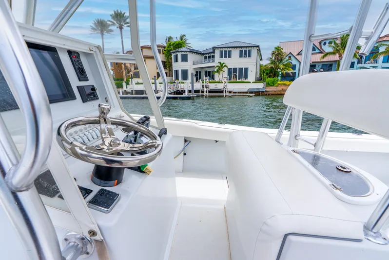  Yacht Photos Pics 2018 Ocean Runner 29 boat interior with steering wheel, overlooking waterfront homes.