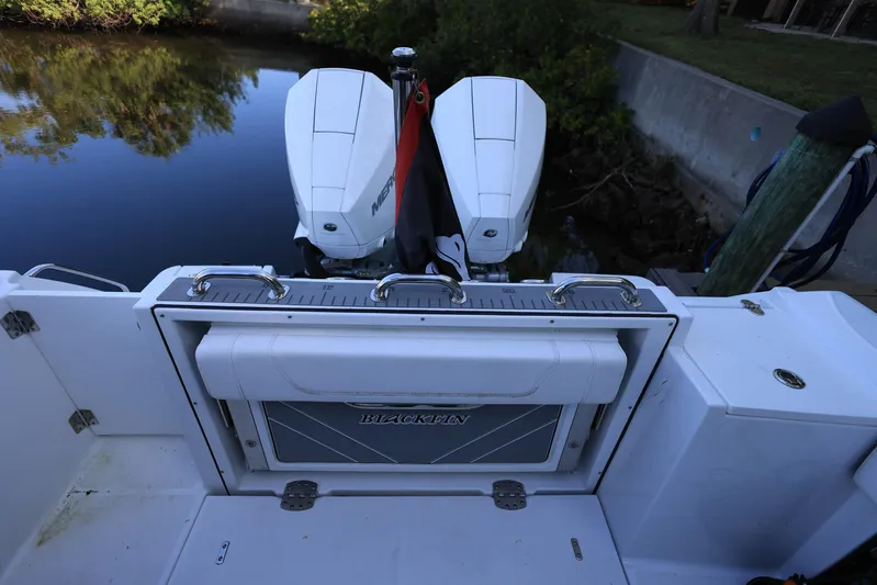  Yacht Photos Pics 2023 Blackfin 252 DC boat with dual outboard motors docked by a canal.
